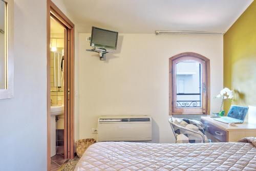 a bedroom with a bed and a desk and a window at Affittacamere nel cuore della Toscana a 20 minuti da Firenze in Empoli
