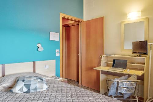a bedroom with a bed and a desk with a computer at Affittacamere nel cuore della Toscana a 20 minuti da Firenze in Empoli