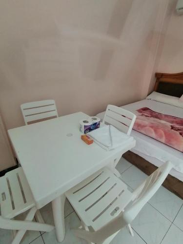 a white table and chairs with a bed in a room at Loyalty apartment in Dumyāţ al Jadīdah