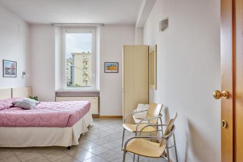 a bedroom with a bed and two chairs and a window at Affittacamere nel cuore della Toscana a 20 minuti da Firenze in Empoli
