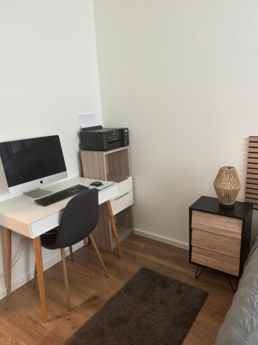 a room with a desk with a computer and a bed at Une Chambre dans un appartement in Ablon-sur-Seine