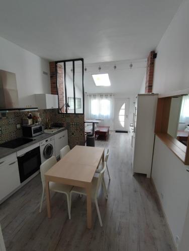 une cuisine et un salon avec une table et des chaises dans l'établissement Appartement T2 48 m2 indépendant parking public gratuit à proximité, à Béziers