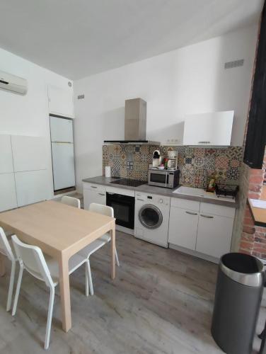 - une cuisine avec une table, une table et des chaises dans l'établissement Appartement T2 48 m2 indépendant parking public gratuit à proximité, à Béziers