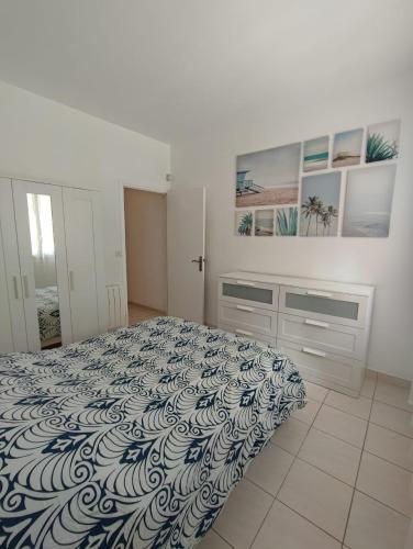 une chambre avec un lit avec un couvre-lit bleu et blanc dans l'établissement Appartement T2 48 m2 indépendant parking public gratuit à proximité, à Béziers