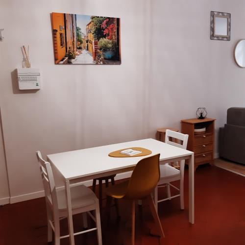 - une table et des chaises blanches dans la chambre dans l'établissement T2 climatisé en centre ville, à Perpignan
