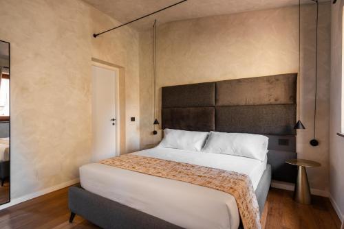 a bedroom with a large white bed with a headboard at Residenza Leutari in Rome