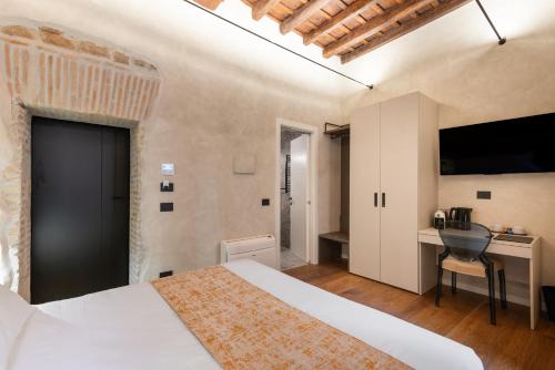 a bedroom with a bed and a desk and a television at Residenza Leutari in Rome