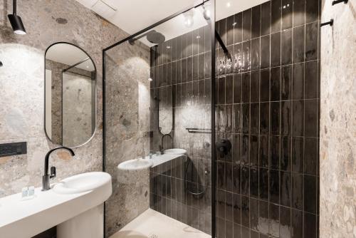 a bathroom with a shower and two sinks and a mirror at Residenza Leutari in Rome