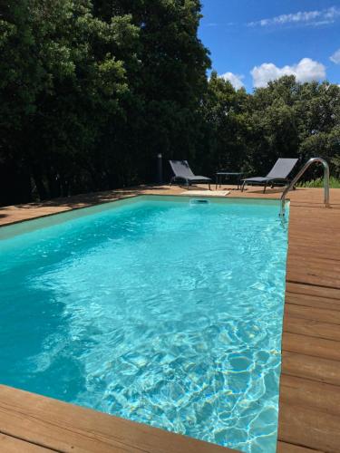 ボレーヌにあるGîte du Planasの大きなプールと椅子2脚、そして