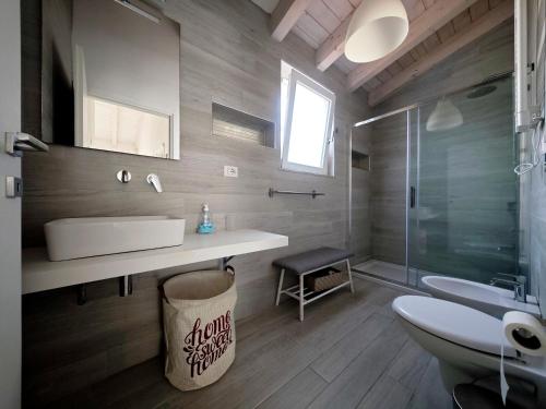 un bagno con lavandino, WC e doccia di IKEBANA VILLAS PORTO PINO BEACH a Porto Pino