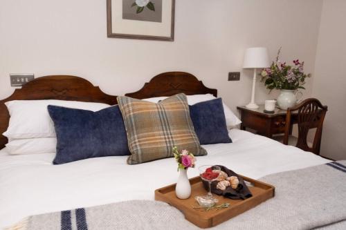 a bed with a tray of food on top of it at The Apple Rooms - Houghton Lodge in Stockbridge
