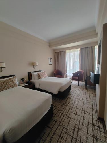 a hotel room with two beds and a window at Hotel Marine Plaza in Mumbai