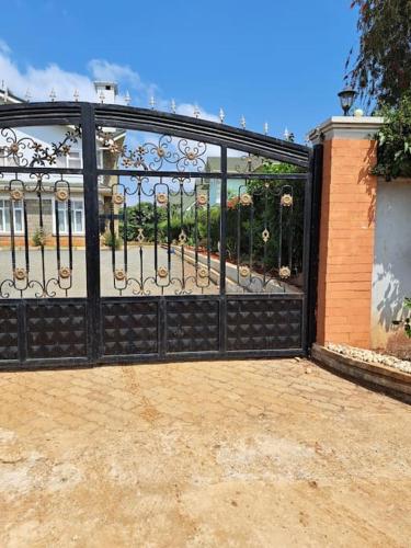 a black metal gate with a garden behind it at Mara Haven - Thika Greens Estate in Thika