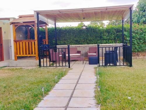 a gazebo with a bench under it in a yard at Mara Haven - Thika Greens Estate in Thika