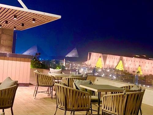 a rooftop patio with tables and chairs at night at New Museum, Pyramids inn in Cairo