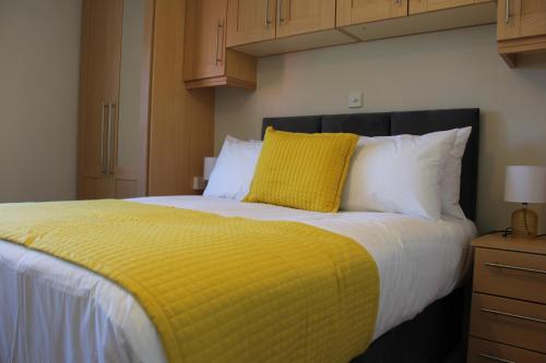 a bedroom with a large bed with a yellow blanket at Dunneill River Rest in Charlesfort