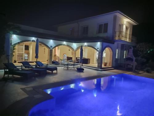eine Villa mit einem Pool in der Nacht in der Unterkunft Casa Santos Kyrenia in Kyrenia