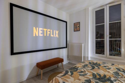 une chambre avec un panneau netflix sur un mur dans l'établissement Rétro movies studio, à Royat