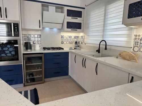 eine Küche mit blauen und weißen Schränken und einem Waschbecken in der Unterkunft Casa Santos Kyrenia in Kyrenia