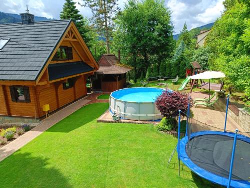 een uitzicht op een achtertuin met een zwembad en een huis bij Willa Rosa in Szczyrk