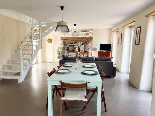 une table blanche et des chaises dans un salon dans l'établissement Jolie maison de vacances à 5 mn à pied des plages, à Landéda