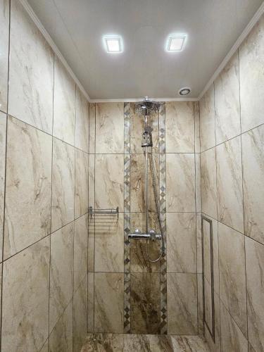 a shower in a bathroom with marble tiles at Cozy Place - в центъра, само на 5 минути пеша от плажа in Burgas