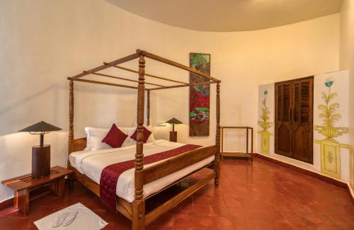 a bedroom with a canopy bed in a room at Mango Hill Yercaud in Yercaud