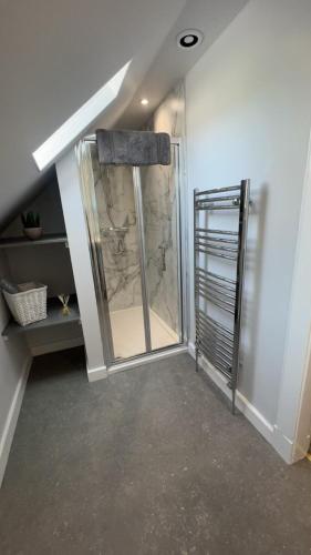 a bathroom with a shower with a glass door at PERGOLA Cottage in Melrose