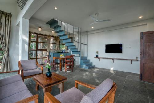 a living room with a staircase and a table at Mango Hill Yercaud in Yercaud
