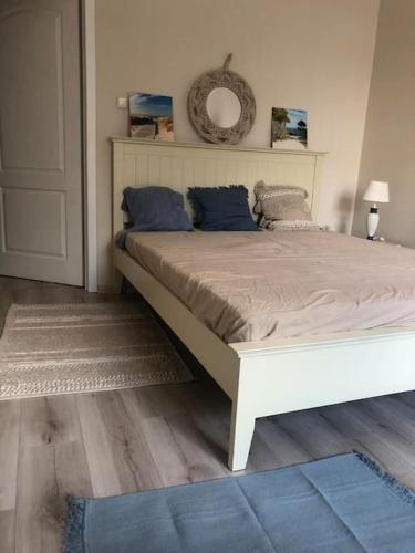 a bedroom with a large white bed with blue pillows at Cosy place in historic building in Šilutė