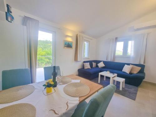 a living room with a table and a blue couch at Apartman Natali in Kremena