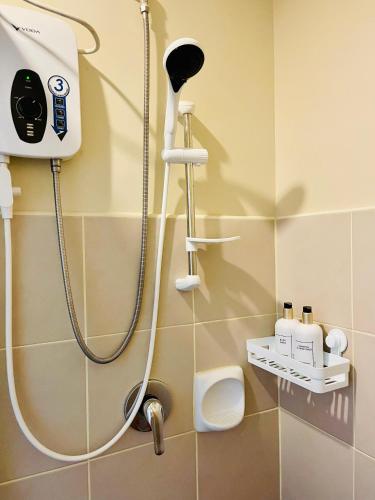 a shower in a bathroom with a blow dryer at Spacious Stylish Studio Unit at Avida Aspira Tower 1 in Cagayan de Oro