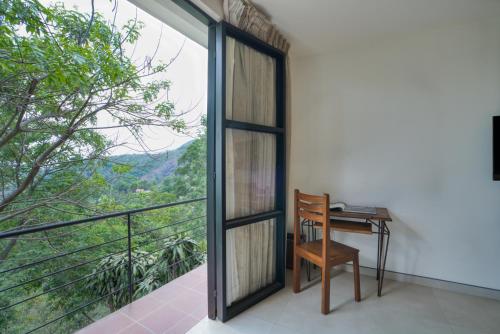 a desk and chair on a balcony with a view at Mango Hill Yercaud in Yercaud