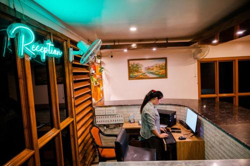 a woman sitting at a computer in a restaurant at HOTEL COUNTRY INN in Dimāpur