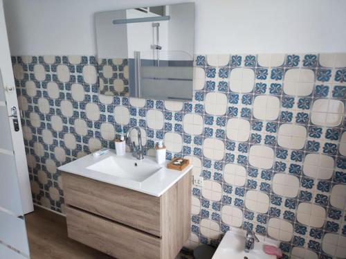 W łazience znajduje się umywalka, lustro i toaleta. w obiekcie Maison avec jardin w mieście Pleumeur-Gautier