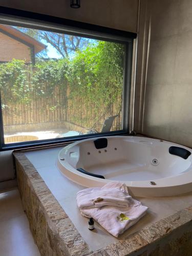 una vasca da bagno in una stanza con una grande finestra di LaPianta a Monte Verde