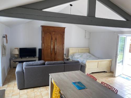 un salon avec un canapé et un lit dans l'établissement Maison chez Meme, à Barbâtre