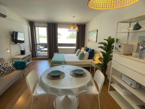 sala de estar con mesa y habitación con cama en Brisa Apartment Vilamoura, en Vilamoura