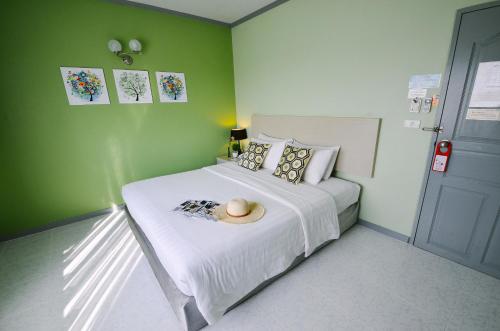 a bedroom with a bed with a hat on it at Thipurai City Hotel in Hua Hin