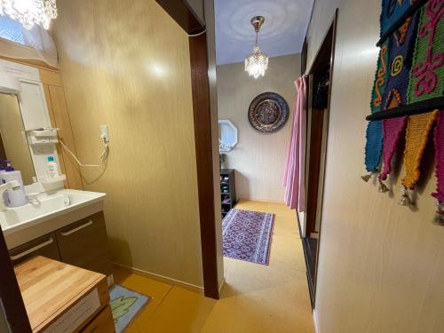 ein kleines Bad mit einem Waschbecken und einem Spiegel in der Unterkunft AnNam Stay TOYONAKA in Toyonaka