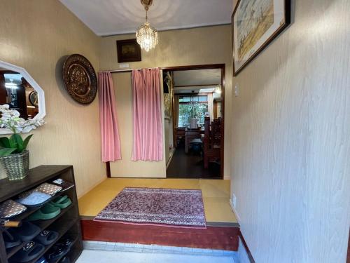 ein Wohnzimmer mit einem Flur mit einer Tür und einem Teppich in der Unterkunft AnNam Stay TOYONAKA in Toyonaka