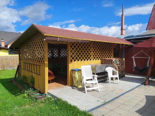 a wooden gazebo with a table and two chairs at Penzion MAYKA in Hrabušice