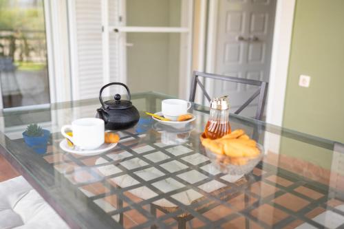 a glass table with two cups and a tea pot on it at Spedion Villa - Near to sea villas with heated swimming pool in Gythio