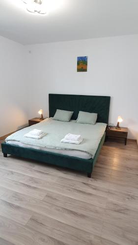 Un dormitorio con una cama con dos mesitas de noche y dos mesas. en MRȘ House 1, en Bucarest