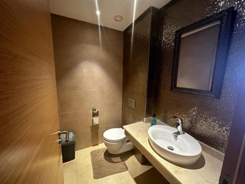 a bathroom with a white toilet and a sink at Luxueux Appartement Plage des Nations in Sidi Bouqnadel