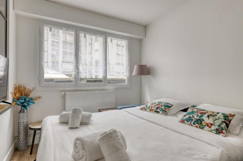 une chambre blanche avec un lit et deux fenêtres dans l'établissement Modern & Pleasant Flat in the Heart of the 15th, à Paris