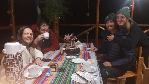 a group of people sitting around a table at the wooden house choquequirao in Cachora
