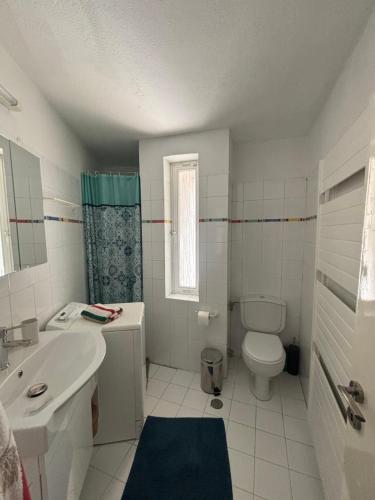 ein weißes Bad mit einem Waschbecken und einem WC in der Unterkunft Country House with Pool and Big Garden in Oropos
