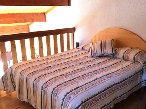 un lit avec une tête de lit en bois dans une chambre dans l'établissement Charmant T2 cabine 6 pers. avec balcon sud, parking privatif à Bolquère - FR-1-592-8, à Bolquère-Pyrénées 2000