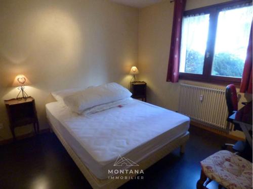 - une chambre avec un lit et deux lampes sur les tables dans l'établissement Confortable 3 pièces pour 6pers avec balcon au Grand-Bornand - FR-1-458-124, au Grand-Bornand